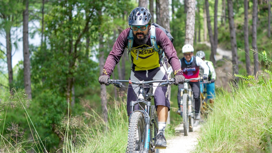 a man riding a bike down a dirt road in a forest